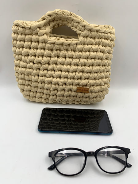 Bolsa de mano en tono arena.