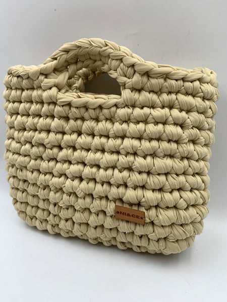 Bolsa de mano en tono arena.